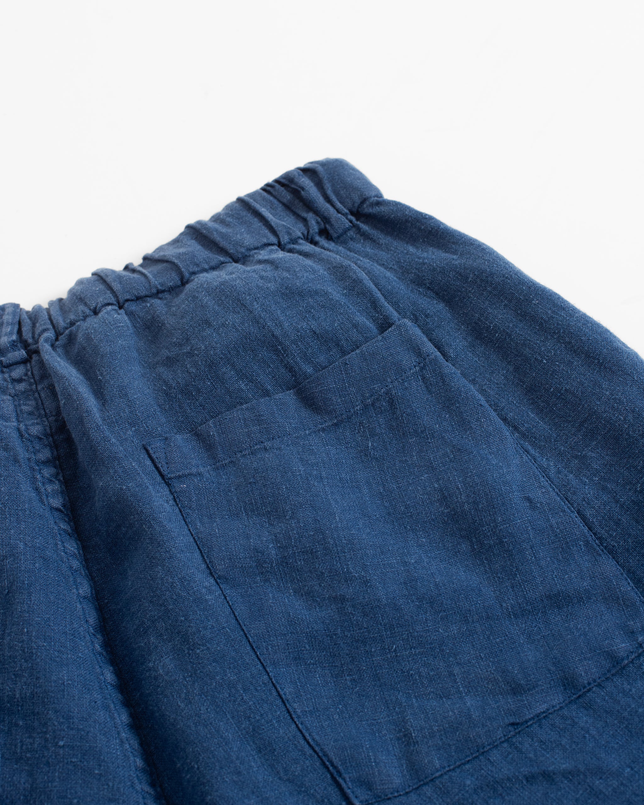 Closeup detail of back pocket on Bather men's blue linen shorts with drawstring
