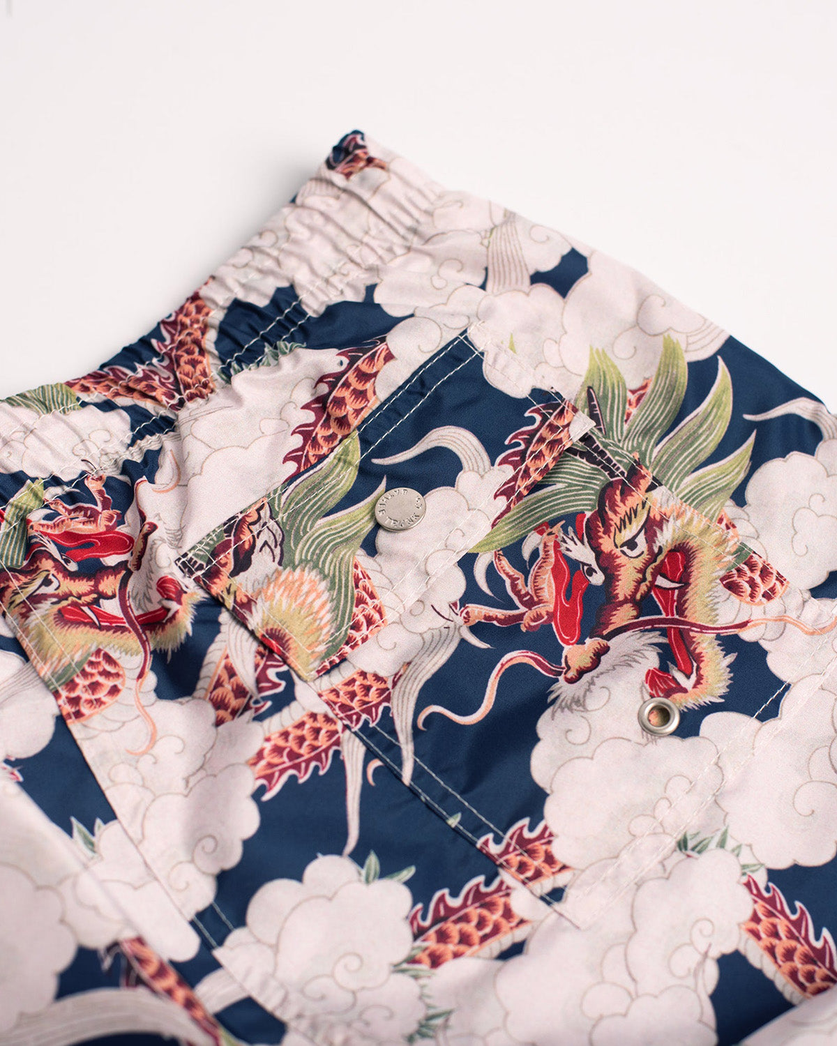 navy Bather swim trunk with white clouds and dragon pattern close up