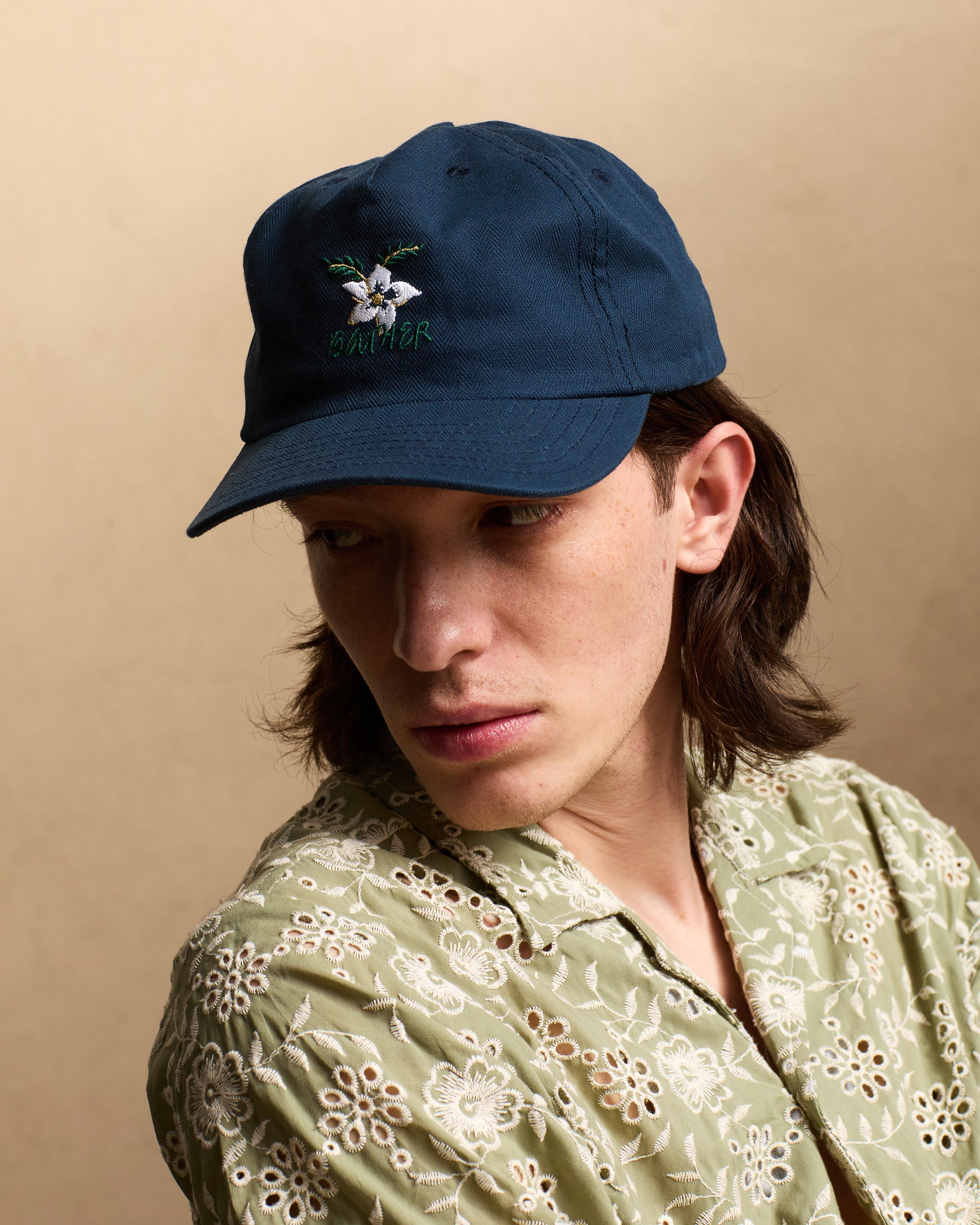 model wearing Dove Herringbone 5 Panel Cap with floral embroidered pattern
