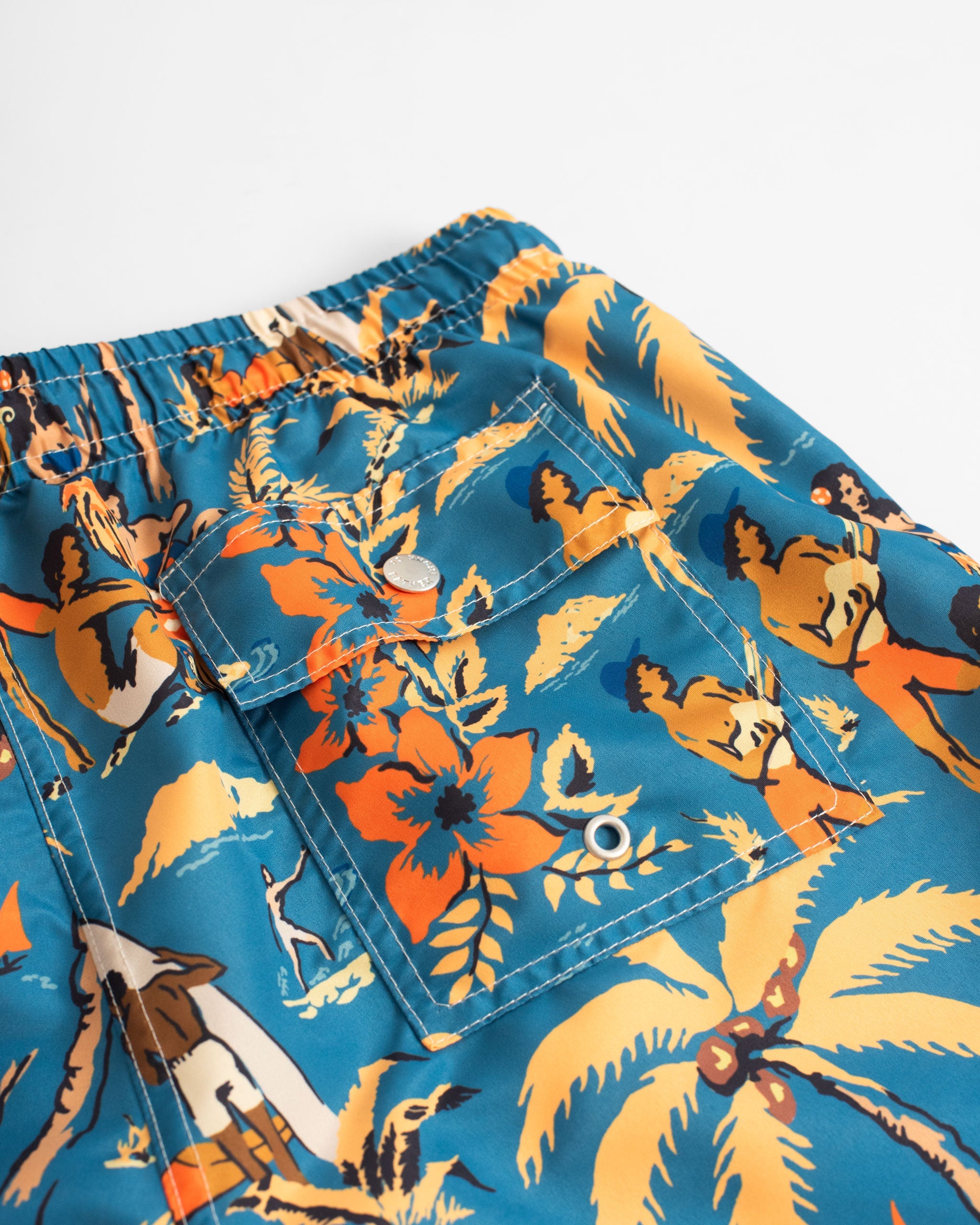 Back Pocket shot of Blue swim trunk with Hawaiian-inspired printed beach scene