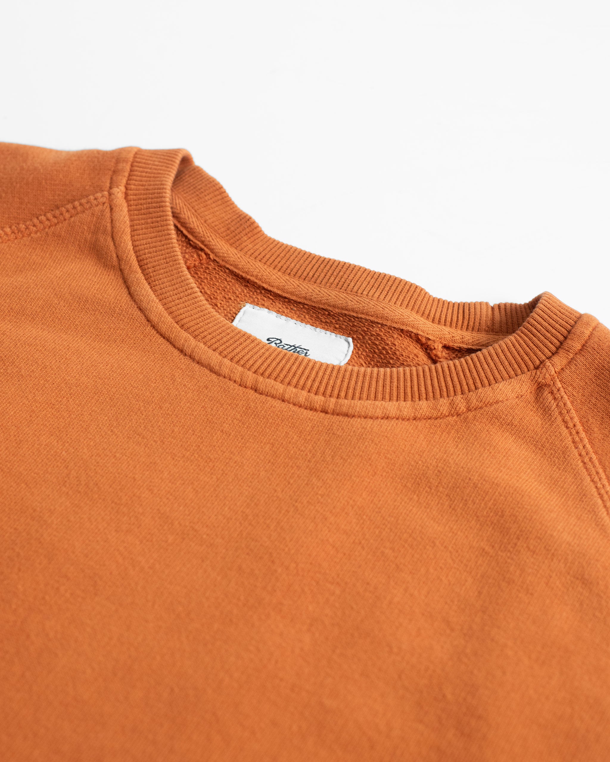 collar close up of Orange french terry raglan sleeve crewneck sweatshirt