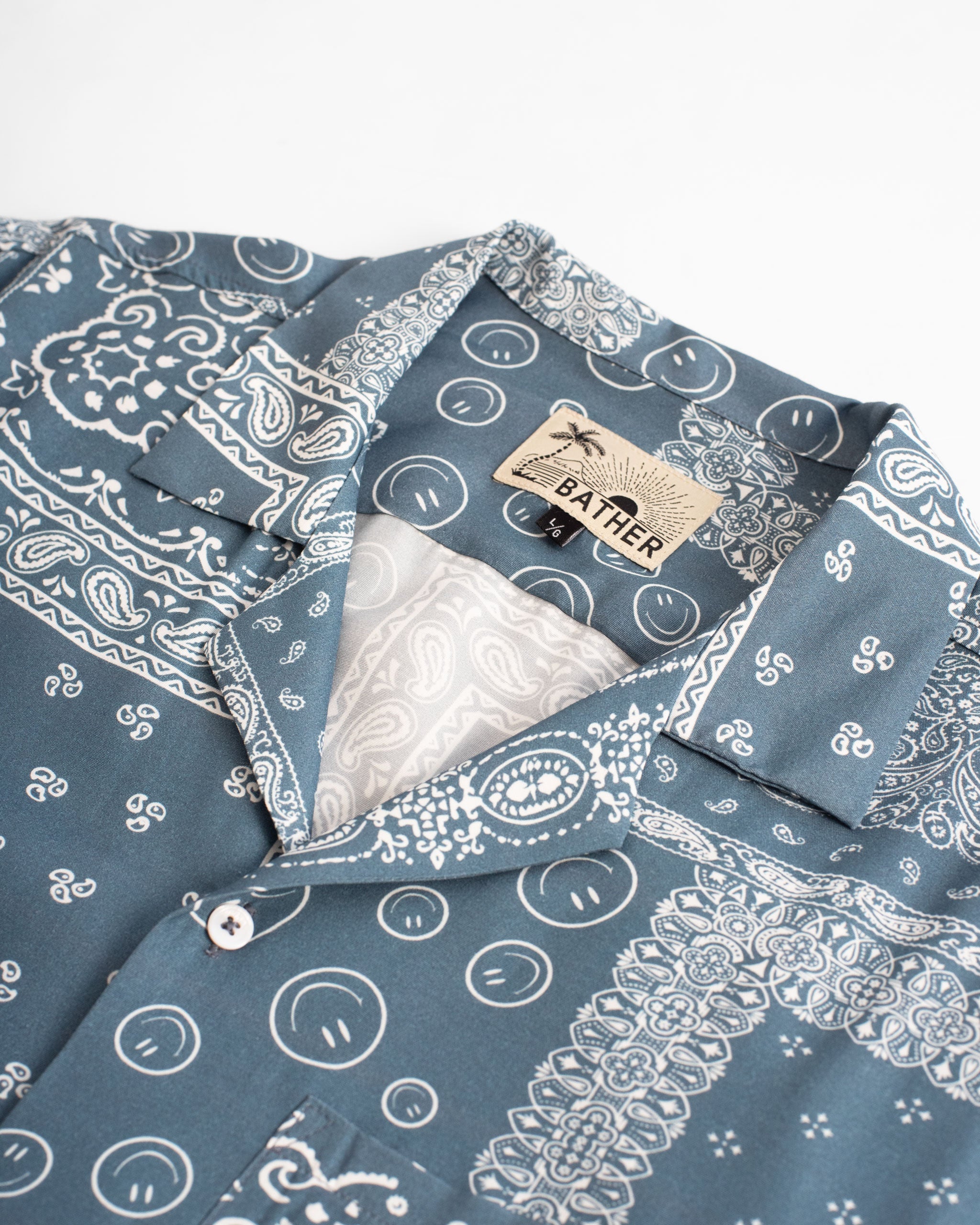 Collar cose up of Blue camp shirt with all-over bandana print