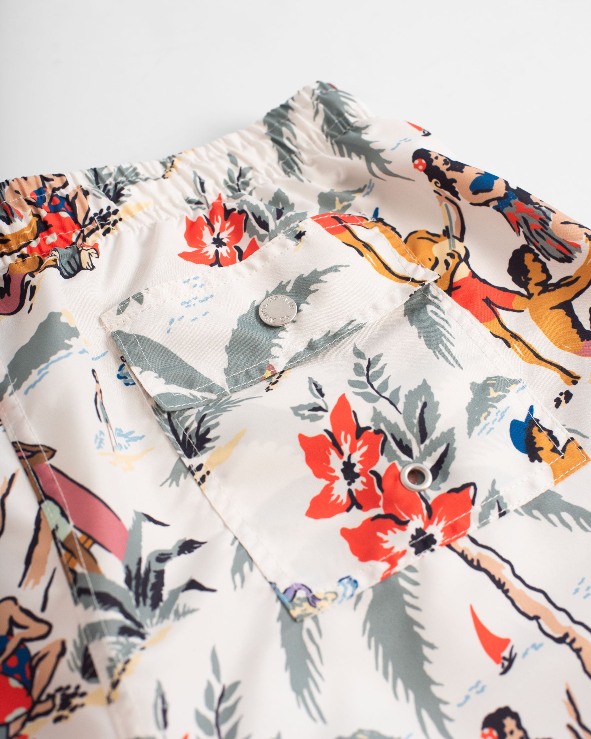 back pocket close up of Cream coloured swim trunk with Hawaiian-inspired beach scene print