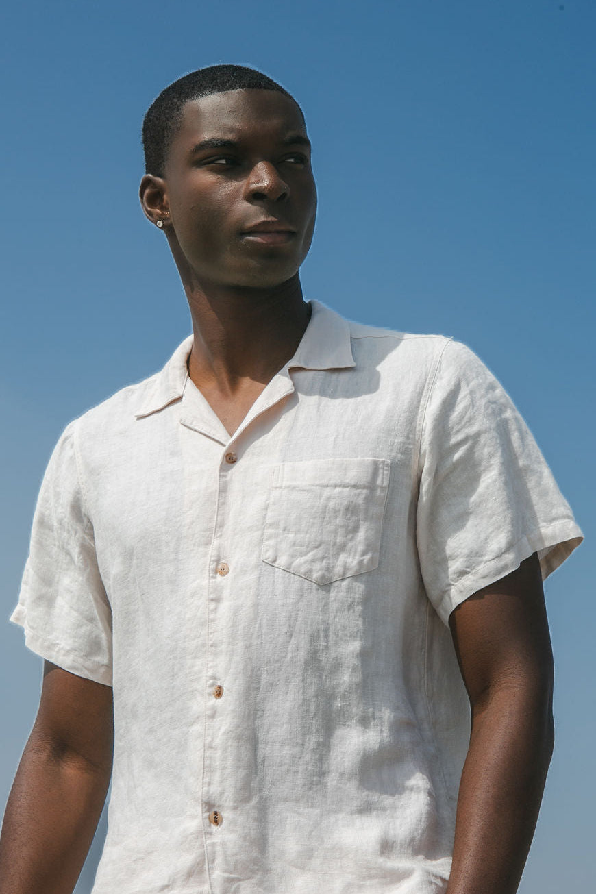 Portrait of a man in a white linen camp shirt looking to the right
