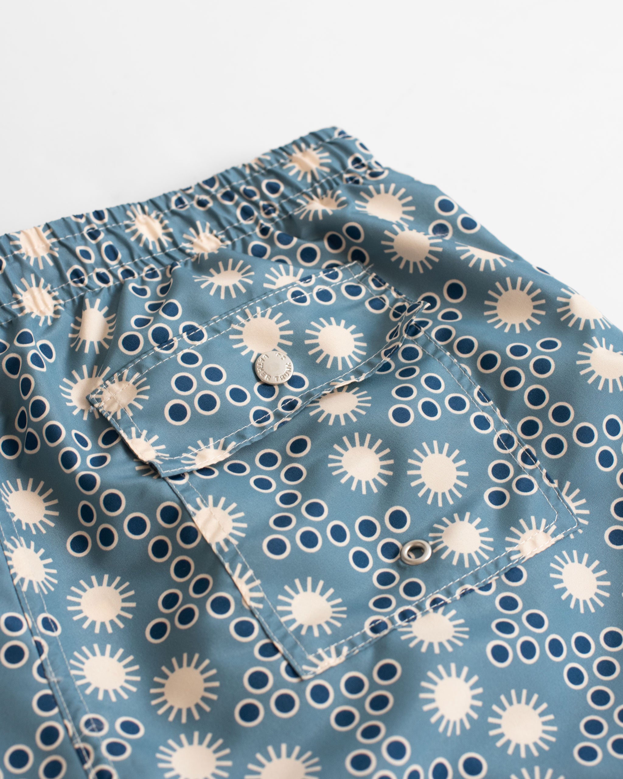 Steel blue disco sun motif all over print swim trunks back pocket close up