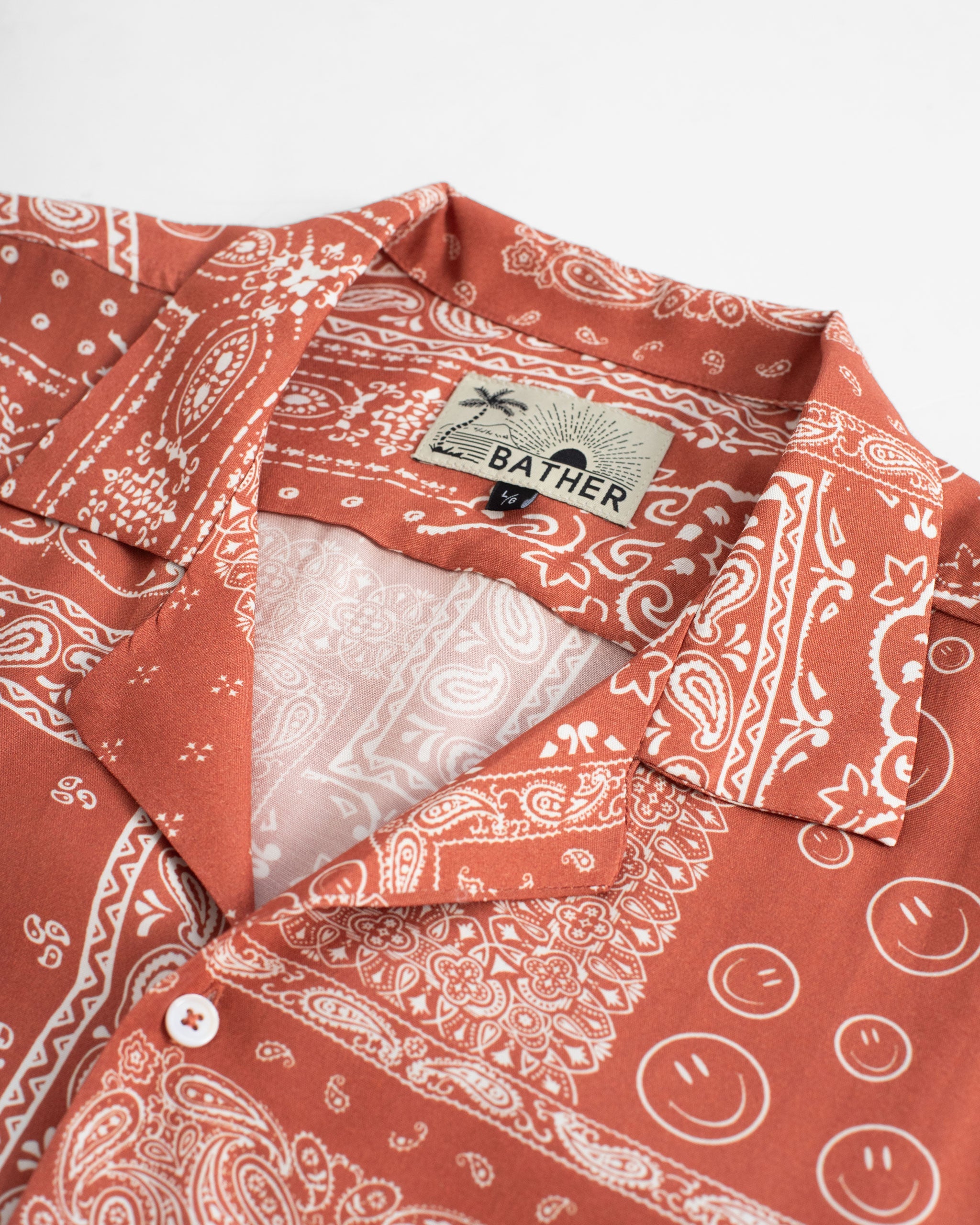 collar close up A terracotta red camp shirt with an all-over bandana print