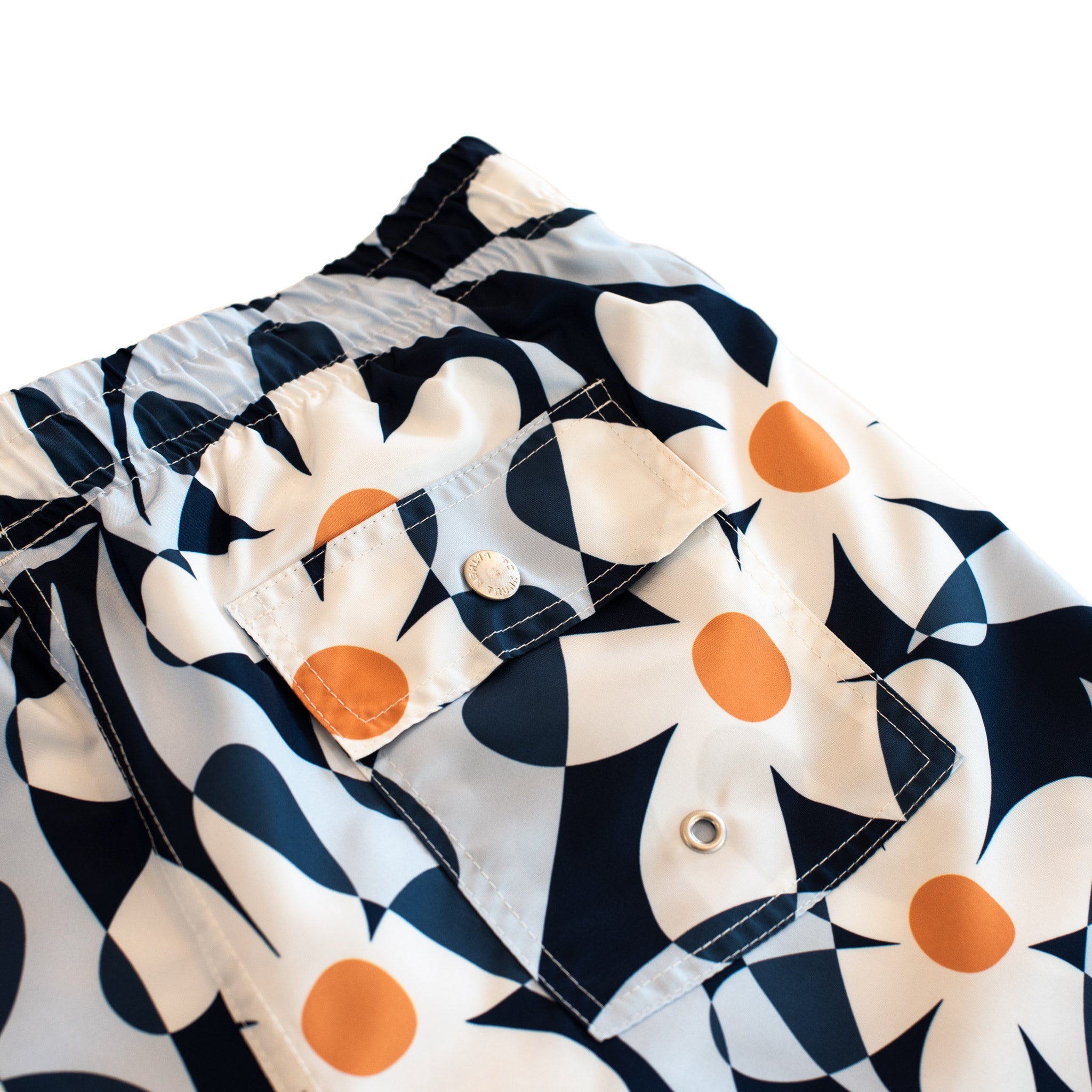 Detail view of blue Bather swim trunks with abstract daisy pattern